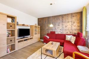 a living room with a red couch and a tv at Ferienwohnung Brune in Schmallenberg