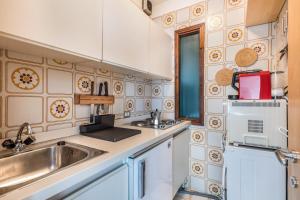 a kitchen with a sink and a microwave at Apt Vista sulla Vallata in Mazzin
