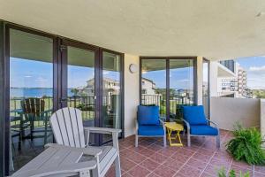 a balcony with chairs and tables and a view of the ocean at Santa Rosa Dunes 923 in Pensacola Beach