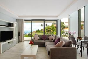 a living room with a couch and a tv at Casa Jolie in Ponta do Sol