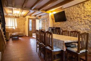 ein Esszimmer mit Tisch, Stühlen und Fernseher in der Unterkunft La Marcela in Peñalba de San Esteban