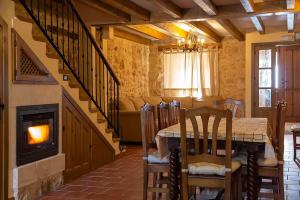 ein Esszimmer mit Tisch und Kamin in der Unterkunft La Marcela in Peñalba de San Esteban + 13 Fotos