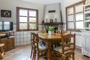 a kitchen with a wooden table with chairs and a tv at Oiaraberri in Errazu