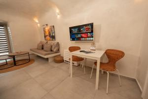 a living room with a table and chairs and a couch at Rody Caves Oia in Oia