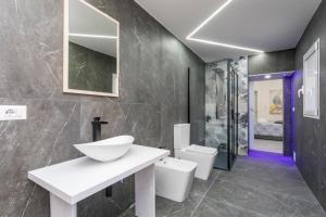 a bathroom with a sink and two toilets at Pm House in Misterbianco +54 photos