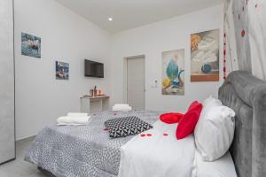 a bedroom with a bed with red and white pillows at Pm House in Misterbianco