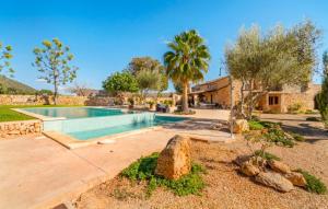 a swimming pool in a yard with trees and a house at Son Gabriela in Llucmajor