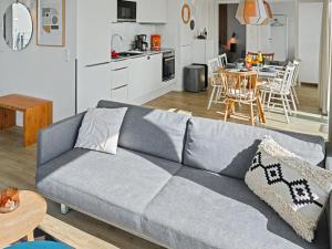 a living room with a gray couch and a kitchen at Apartment Penthouse Dümmerblick - 619 by Interhome in Lembruch