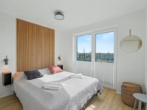a bedroom with a bed and a large window at Apartment Penthouse Dümmerblick - 619 by Interhome in Lembruch