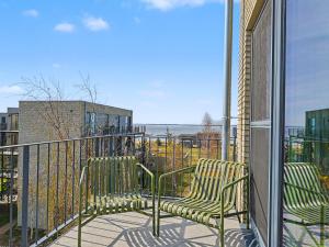 two chairs on a balcony with a view of the ocean at Apartment Penthouse Dümmerblick - 619 by Interhome in Lembruch