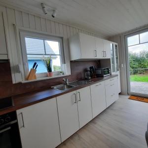 a kitchen with white cabinets and a large window at Haus Abendsonne in Wandlitz