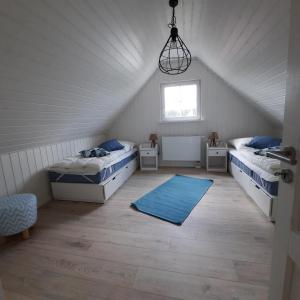 a attic room with two beds and a window at Haus Abendsonne in Wandlitz