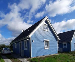 a blue house with a car parked in front of it at Haus Abendsonne in Wandlitz