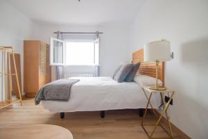 a bedroom with a bed with a lamp and a window at La Casa del Alcalde in Ceguilla +10 photos