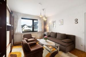 a living room with a couch and two chairs at Ferienwohnung Sonnenring in Rüthen
