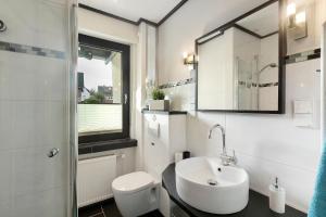 a bathroom with a sink and a toilet and a mirror at Ferienwohnung Sonnenring in Rüthen +19 photos