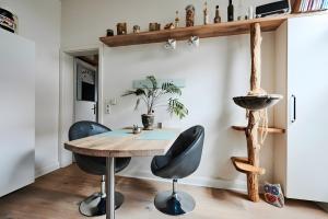 a dining room with a wooden table and two chairs at Einzigartige Tischlerwohnung in Oldenburg