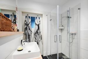 a white bathroom with a sink and a shower at Einzigartige Tischlerwohnung in Oldenburg +13 photos