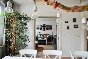 a living room with white chairs and a table at Einzigartige Tischlerwohnung in Oldenburg