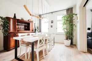 a dining room with a table and a piano at Einzigartige Tischlerwohnung in Oldenburg