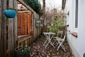 a patio with two chairs and a table in a yard at Einzigartige Tischlerwohnung in Oldenburg