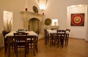 a dining room with tables and chairs and a fireplace at Masseria La Porticella in Avetrana