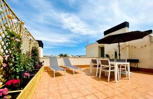 a patio with a table and chairs and an umbrella at Atico Solarium La Cala in Miami Platja