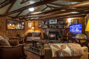 a living room with a couch and a tv at Log Cabin in Helen