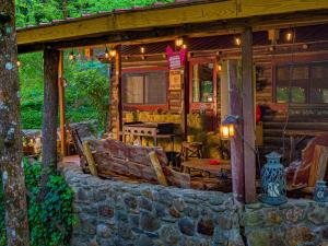 a porch of a log cabin with a stone wall at Log Cabin in Helen