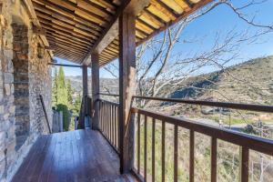 a wooden porch with a view of the mountains at Rectoria de Claverol in Claverol