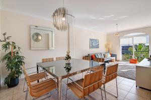 a dining room and living room with a table and chairs at Vilamoura Golfe Mar in Quarteira