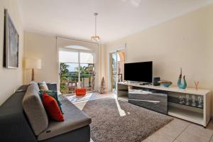 a living room with a couch and a television at Vilamoura Golfe Mar in Quarteira