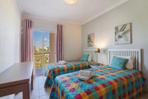 two beds in a room with a window at Vilamoura Golfe Mar in Quarteira +18 photos