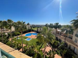 an aerial view of a resort with a pool and palm trees at Vilamoura Golfe Mar in Quarteira