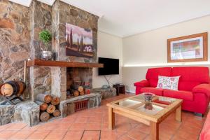 a living room with a red couch and a stone fireplace at Casa Paca in Maspalomas