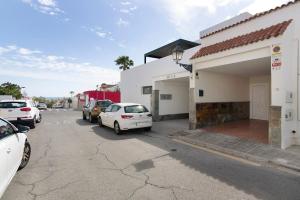 a parking lot with cars parked in front of a building at Casa Paca in Maspalomas