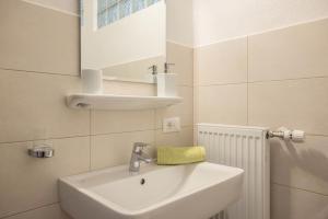 a white bathroom with a sink and a mirror at Unterhauserhof App A in Valdaora +9 photos
