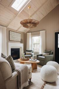 a living room with a couch and chairs and a chandelier at The Townie Cottages by Juniper Holiday + Home in Union Pier