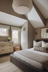 a bedroom with a large bed and a dresser at The Townie Cottages by Juniper Holiday + Home in Union Pier