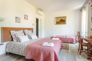 a white bedroom with two beds and a desk at Chambre d'hote Rubis in Genouillé +33 photos