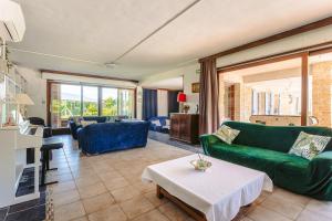 a living room with a green couch and a table at Chambre d'hote Rubis in Genouillé