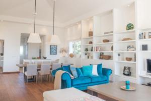 a living room with a blue couch and a dining room at Villa Muscari in Benalup Casas Viejas