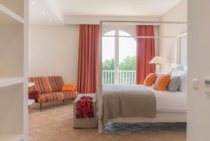 a bedroom with a bed and a chair and a window at Villa Muscari in Benalup Casas Viejas +35 photos