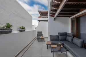 a balcony with a couch and chairs on a building at Mar in Playa Honda