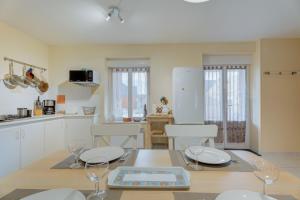 a kitchen with white cabinets and a table with wine glasses at Grain de vanille in Saint-Benoît-des-Ondes