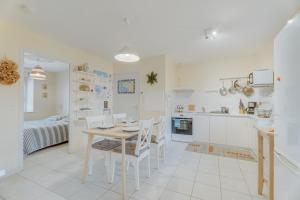 a kitchen and living room with a table and chairs at Grain de vanille in Saint-Benoît-des-Ondes