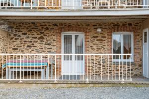 a balcony with a bench on a brick building at Grain de vanille in Saint-Benoît-des-Ondes