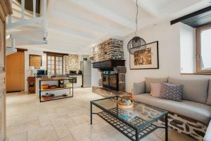 a living room with a couch and a fireplace at Maison Plage Verger Cancale in Cancale