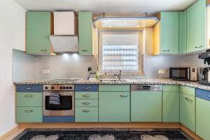 a kitchen with green cabinets and a sink at Ferienwohnung Leon in Kappel-Grafenhausen