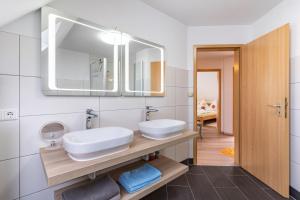 a bathroom with two sinks and a mirror at Ferienwohnung Leon in Kappel-Grafenhausen +19 photos